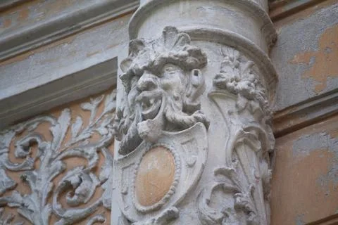 Old column with a bas-relief in the form of a demonic face. Kiev, Ukraine Stock Photos