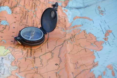 Old compass on the Russian-language map of the world. Concept. Stock Photos