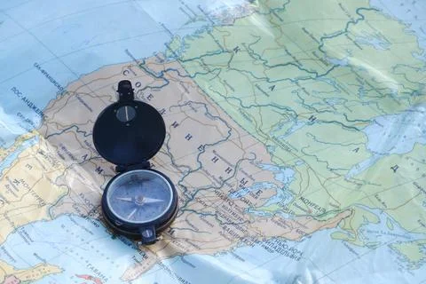 Old compass on the Russian-language map of the world. Concept. Stock Photos