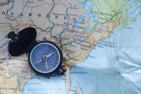 Old compass on the Russian-language map of the world. Concept. Stock Photos