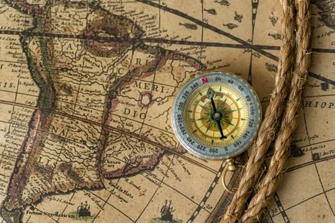 Old compass on vintage map with rope Stock Photos