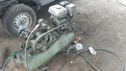An old compressor machine in the workshop that is worn and dirty Stock Photos