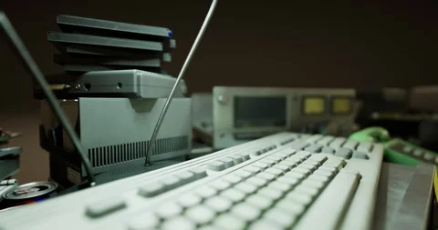Old computer equipment on a desk with a keyboard and various devices Stock Footage 315535414