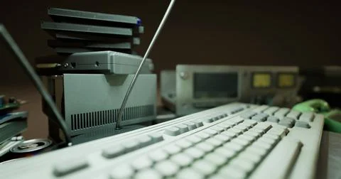 Old computer equipment on a desk with a keyboard and various devices イラスト素材