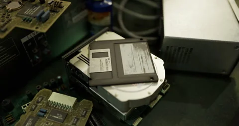 Old computer hardware and floppy disk on a workbench in a workshop Stock Footage 318679907