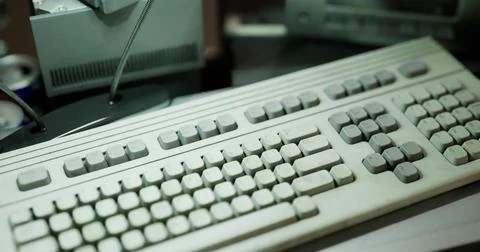 Old computer keyboard and equipment on a desk with soft lighting Stock Illustration