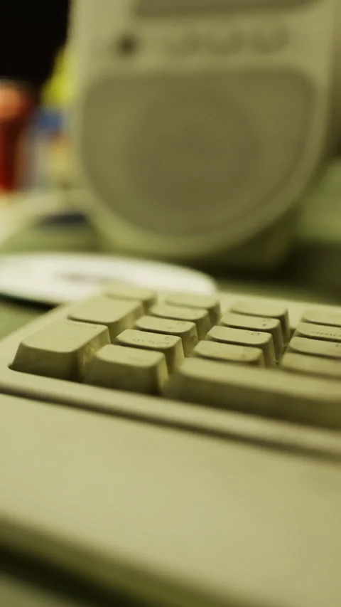 Old computer keyboard and speaker in a workspace setting with various items Stock Footage 334725508