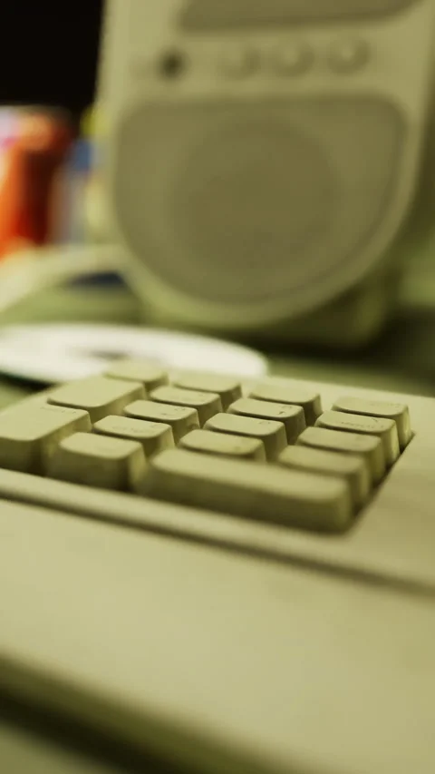 Old computer keyboard and speaker on a desk in a busy workspace Stock Footage 335964366