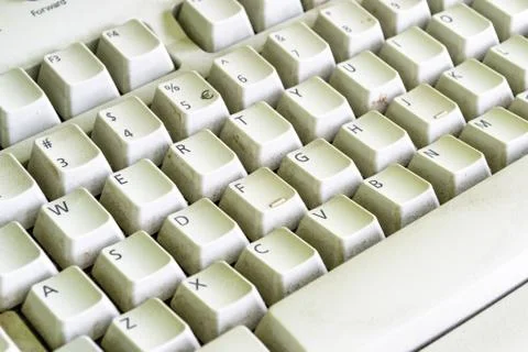 Old computer keyboard, once white, with dust between the keys. Diagonal pattern Stock Photos