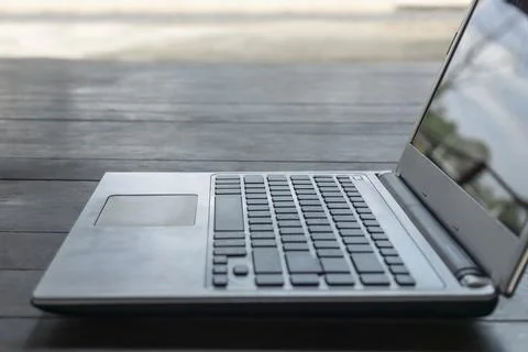 Old computer laptop or notebook empty on a wood table with a black screen, .. Stock Photos
