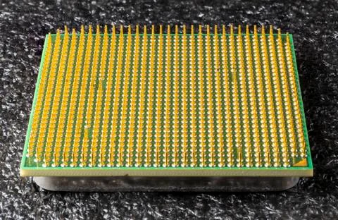 Old computer processor with gold-plated legs, on a black soft backing Stock Photos
