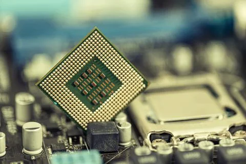 An old computer processor stands on background of motherboard 写真素材