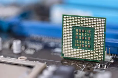 An old computer processor stands on background of motherboard 写真素材