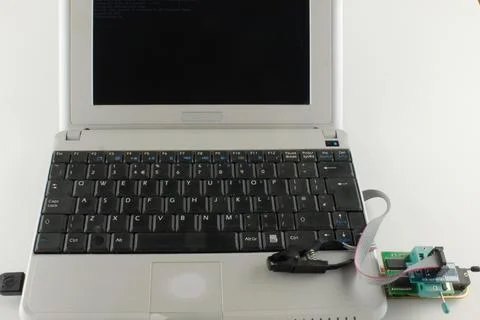 Old computer technology a netbook with usb programmer connected Foto stock