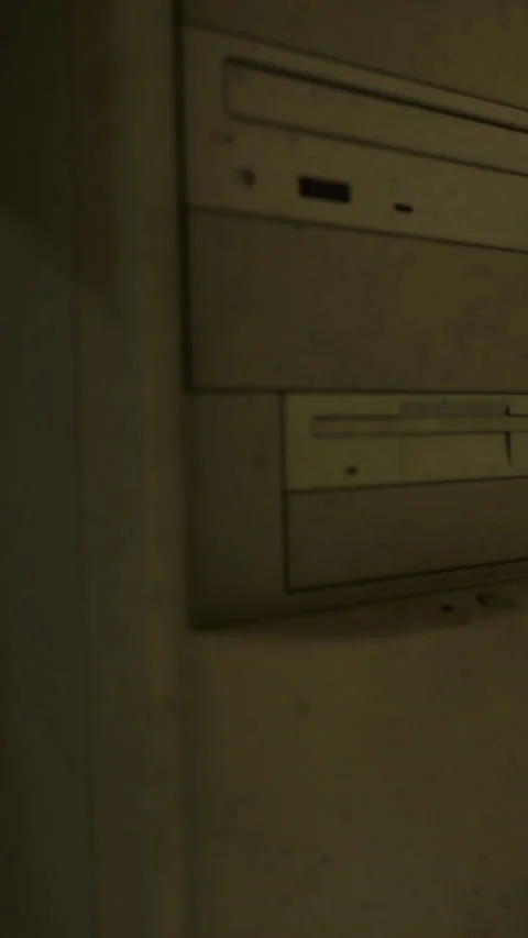 Old computer tower sits against a wall in a dimly lit room Stock Footage 334263156