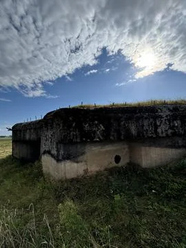 Old concrete bunker under a dramatic cloudy sky Stock Photos