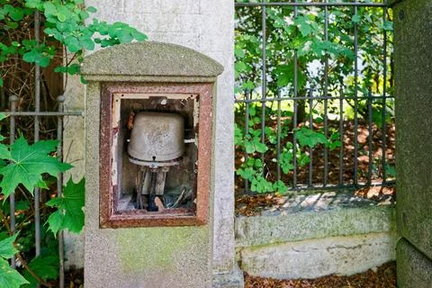 Old concrete post with open utility box and tangled wires Stock Photos