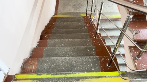 An old concrete staircase with yellow warning stripes and a metal handrail Vídeo Stock 331332003