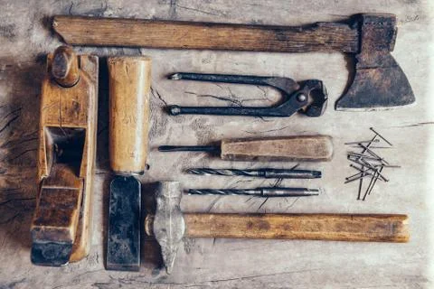 Old construction tools on a wooden workbench flat lay background. Carpenter t Stock Photos