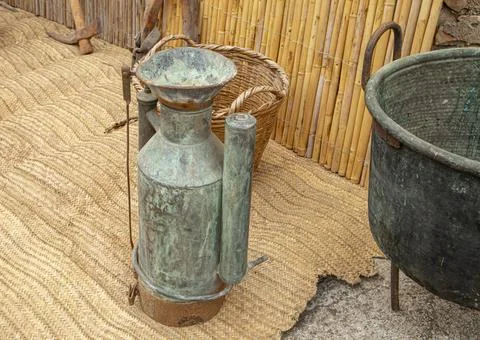 Old copper backpack agricultural sprayer with brass funnel alongside antiqu.. Stock Photos