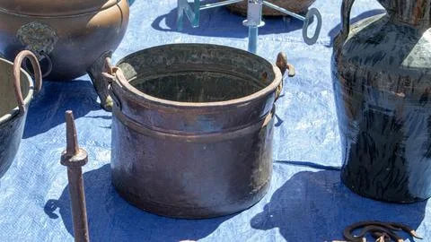 Old copper cooking pot with handle displayed next to vintage ceramic jugs a.. Foto stock