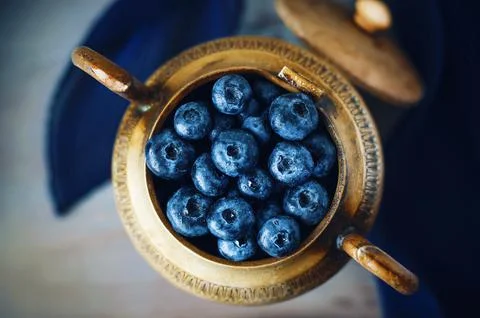 In an old copper vase with patterns, standing on the table, there is a handfu Foto stock