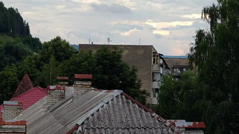 Old corrugated roofs and brick chimneys of mountain town building Stock Footage 340479525