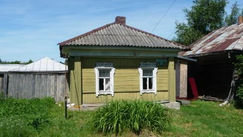 Old cottage covered with boards with carved platbands on the Windows. Foto stock