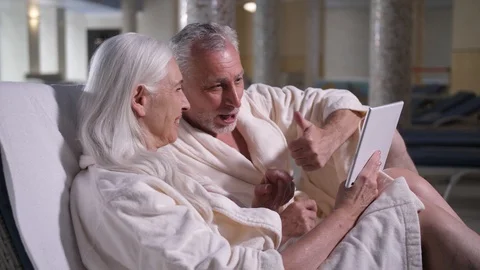 Old couple conversating online on tablet in hotel Stock Footage 114833705