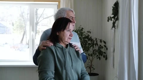 Old couple have breakfast sitting at the kitchen table, drink coffee. Embracing Stock Footage 328620512