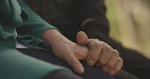 Old couple holding hands. Close up of hands of aged couple caring each other . Stock Footage