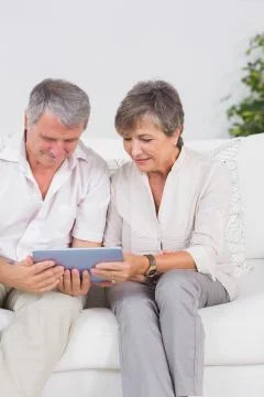 Old couple looking tablet pc with smiling Foto stock