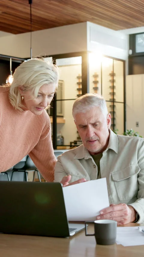 Old couple, reading and document at house with laptop, research or letter for Stock Footage 337499366