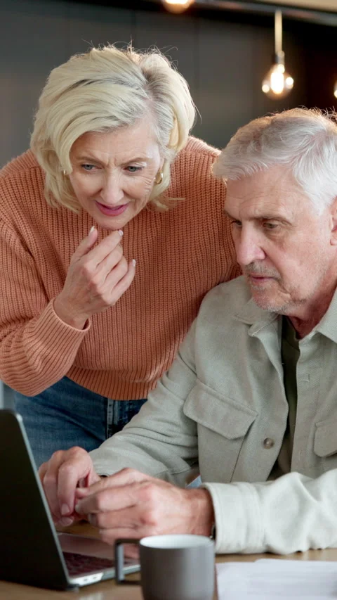 Old couple, reading and talk in home with laptop, research and document for Stock Footage 337481396
