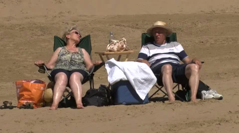 Old couple sitting on beach Stock Footage 51750871