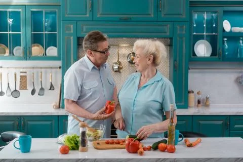 Old couple talks while cooking a salad Stock Photos