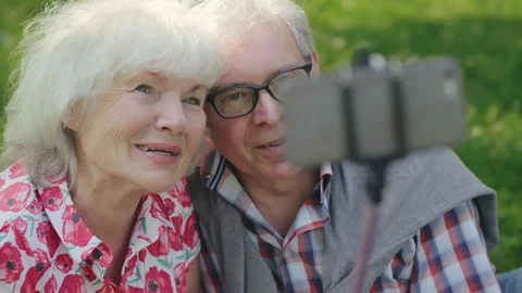 Old couple using selfie stick Stock Footage 114129634