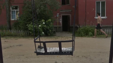 Old courtyard with a swing, swing. boy enters the house.Krichev Stock Footage 55214569