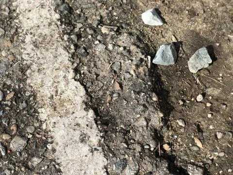 Old crashed road. Black pebbles background. Stones in the asphalt ground Stock Photos