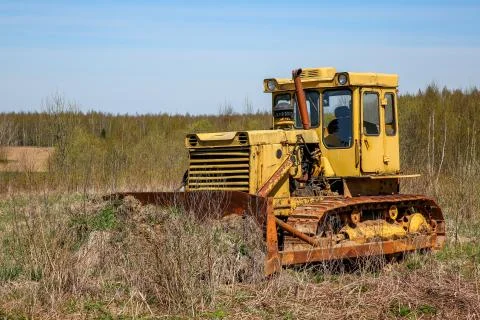 Old crawler tractor in the field. Stock Photos