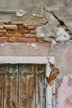 Old crumbling wall and window frame with weathered wood of an old shutter, Stock Photos
