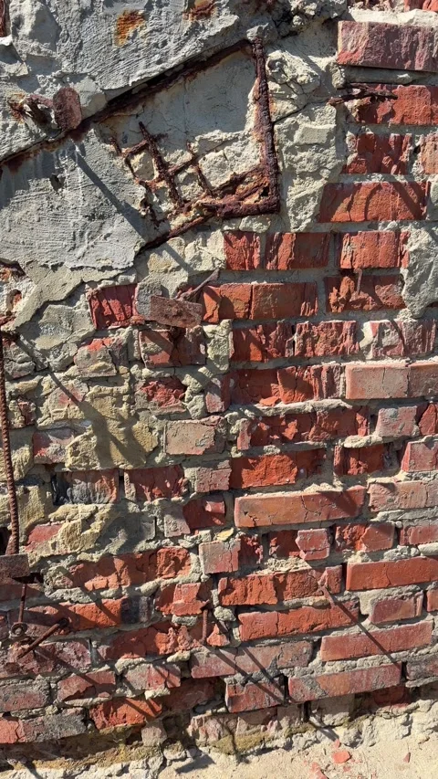 An old damaged red brick wall with cracked concrete texture and rusty metal Stock Footage 336901348
