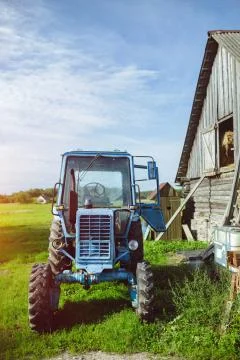 Old damaged tractor by the barn Stock Photos