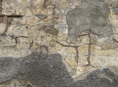 Old damaged wall with peeling plaster and deep cracks, weathered building s.. Stock Photos
