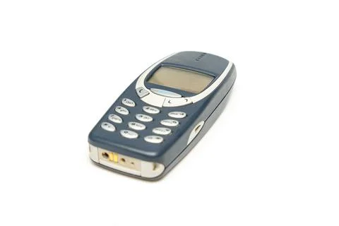 Old dark push-button mobile phone isolated on white background. Stock Photos