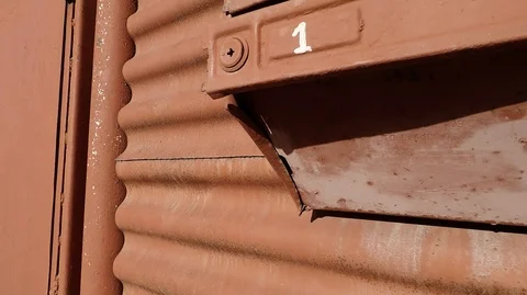Old dark red metal mailboxes with numbers from 1 to 4 Stock Footage 125788526
