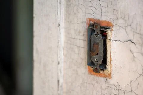 Old decapitated wall with a weathered light switch set in the off position Stock Photos