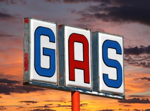 Old decayed gas sign with sunset sky Stock Photos