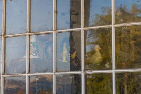 Old decorative objects behind the window of an abandoned gas station in Maryhill Stock Photos