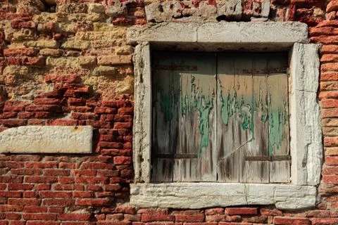 Old decrepit shuttered window in a crumbling brick wall Stock Photos